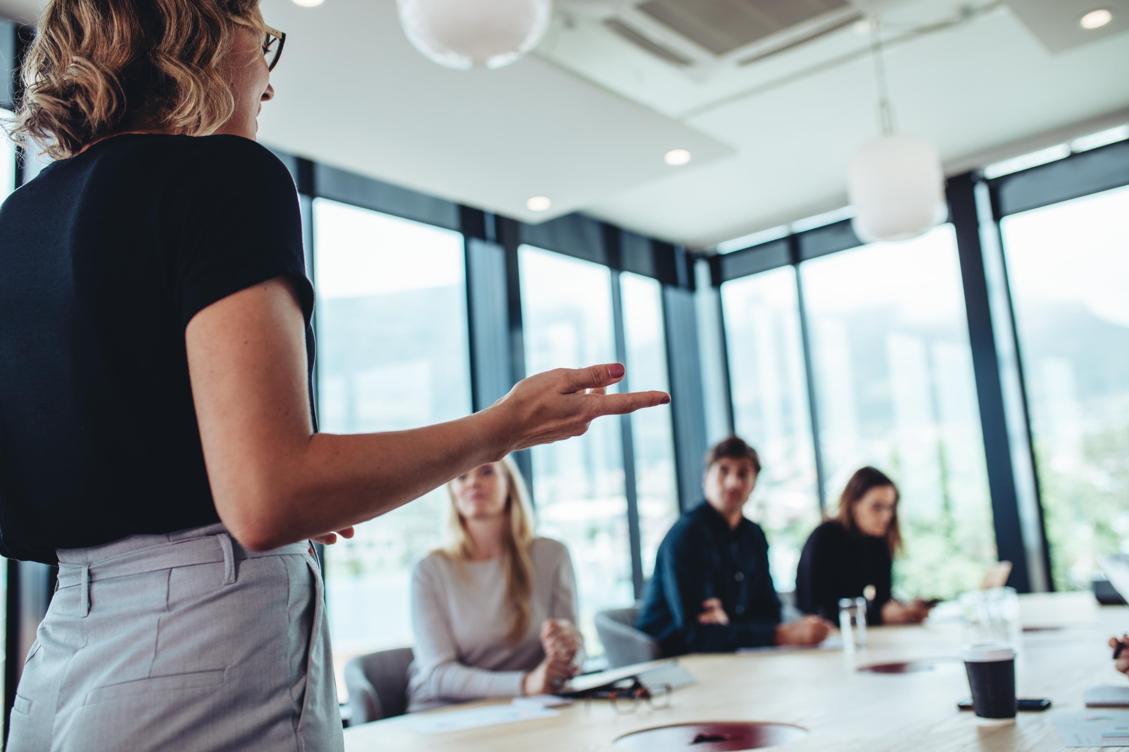 A businesswoman makes a presentation to her colleagues in office.