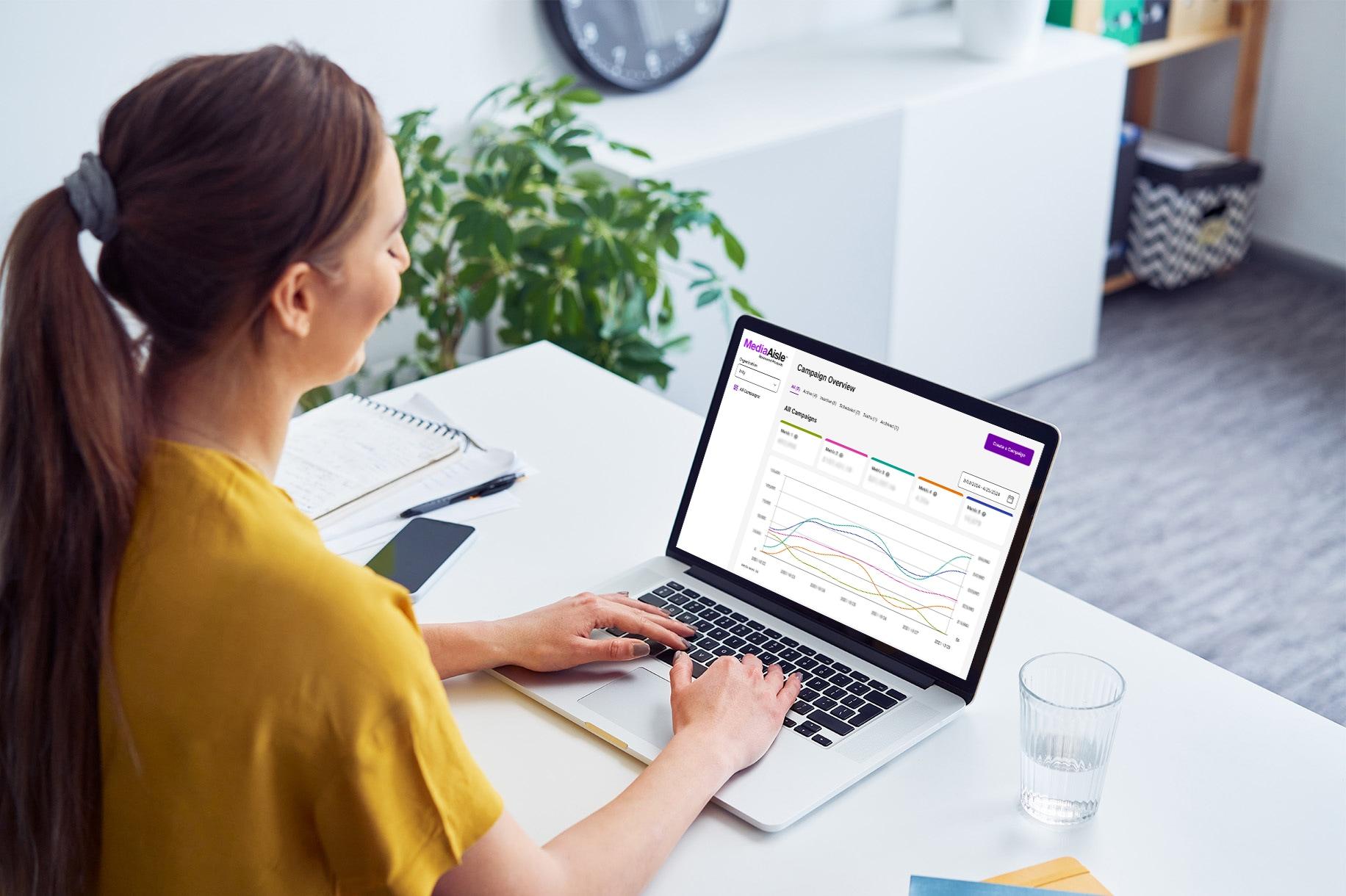 A woman views the MediaAisle dashboard to check her campaign performance.